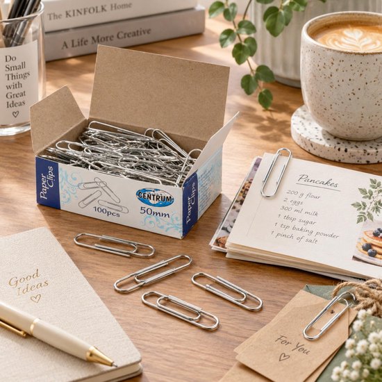 Doos met 100 Centrum zilveren paperclips van 50 mm naast een recept voor pannenkoeken op een bureau.
