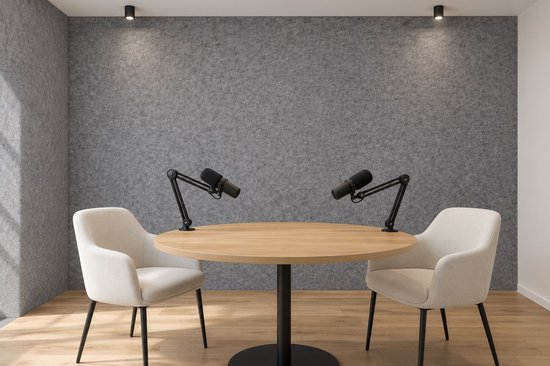 Podcaststudio met grijze viltwand, ronde houten tafel, twee stoelen en microfoons.