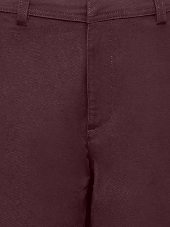 Close-up van de bordeauxrode textuur en stiksels bij de taille en gulp van een ONLY broek.