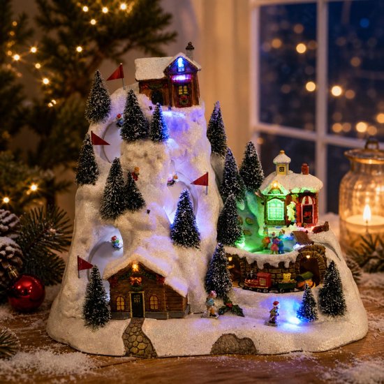 Lumineo skipiste kerstdorp met verlichte huisjes, besneeuwde bergen, kleine dennenbomen en bewegende figuren.