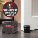 Zwarte deurstopper naast de deur, met een label dat aangeeft 'Verhindert deuren van sluiten'.