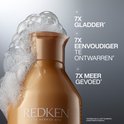 Flacon de shampoing Redken doré avec de la mousse et le texte : '7x plus lisse', '7x plus facile à démêler', '7x plus de douceur'.