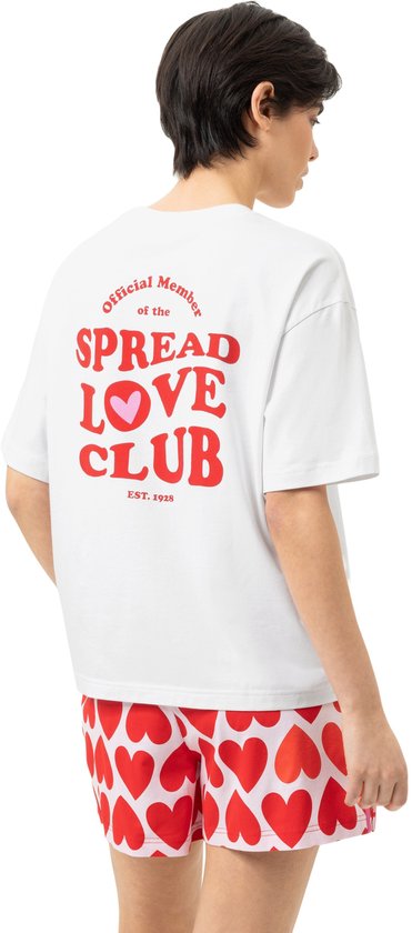 Model van achteren gezien draagt een wit T-shirt met rode tekst 'Official Member of the SPREAD LOVE CLUB EST. 1928' en een hartje.