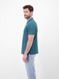 Zijaanzicht van een blauwe polo met donkerblauwe kraag en knopen, model