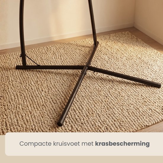 Compacte kruisvoet van een zwarte metalen hangstoelstandaard met krasbescherming op een vloerkleed.