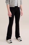 Model draagt een zwarte flared legging, gecombineerd met een grijze gebreide vest en zilverkleurige sneakers.