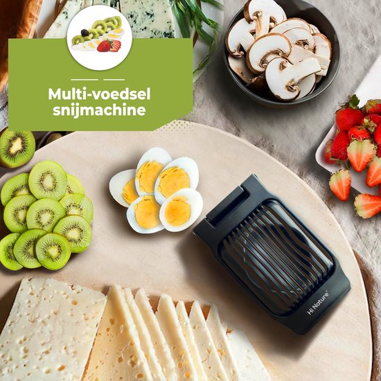 Zwarte eiersnijder op een snijplank met gesneden kiwi, ei, champignons, aardbeien en kaas.