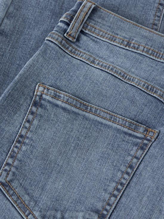 Detail van de achterkant van een lichtblauwe spijkerbroek met bruine stiksels en twee zakken.