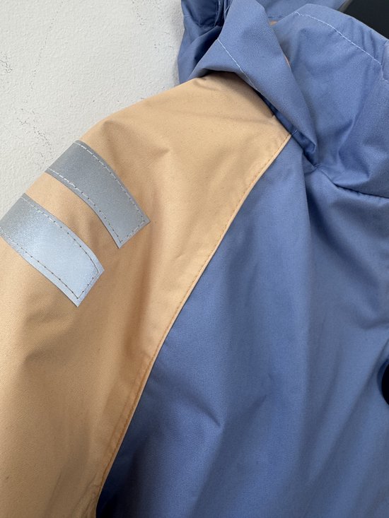 Blauwe jas met beige accenten, met reflecterende strepen op de mouw.