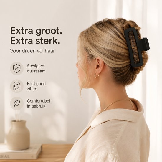 Zwarte, extra grote en sterke haarklem in het blonde haar van een vrouw, speciaal voor dik en vol haar.