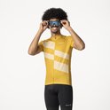 Man met afro draagt geel fietsshirt, met diagonale strepen, zwarte fietsbroek en zonnebril.