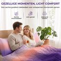 Een koppel in bed onder een paars, roze en oranje gradiënt dekbed. Kussenslopen met bijpassend patroon.