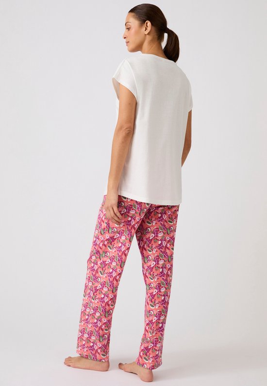 Model van achteren in een wit T-shirt met korte mouwen en een roze pyjamabroek met tropische print.