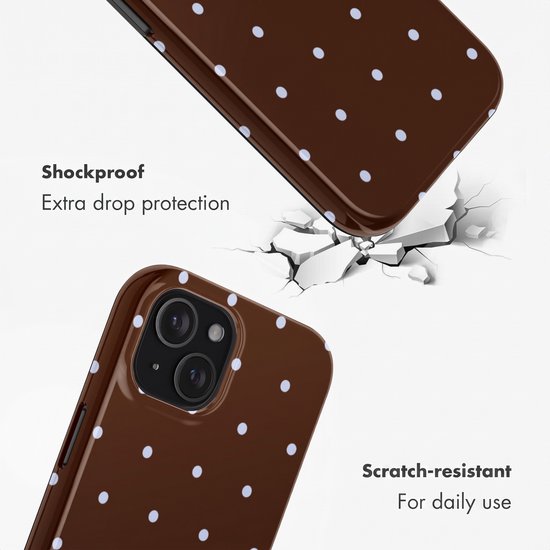 Bruin telefoonhoesje met witte stippen dat op een gebarsten oppervlak valt.