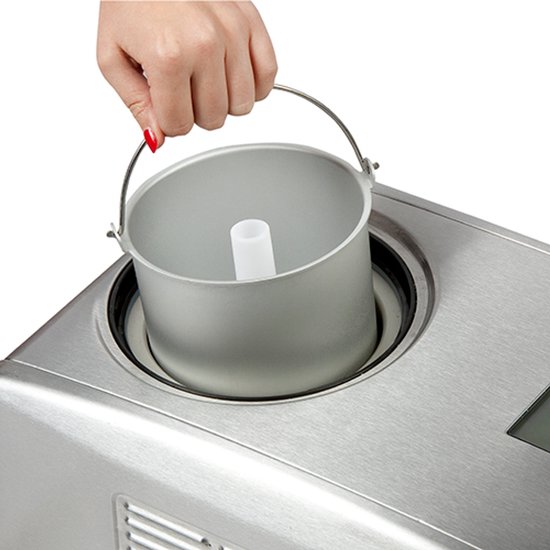 Zilverkleurige kom met handvat wordt uit de machine gehaald.