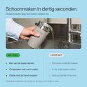 Hand spoelt een beige melkopschuimer af onder de kraan.
