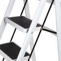 Gedetailleerd zicht op de onderste treden van de witte inklapbare trap met zwarte antislip pedalen.