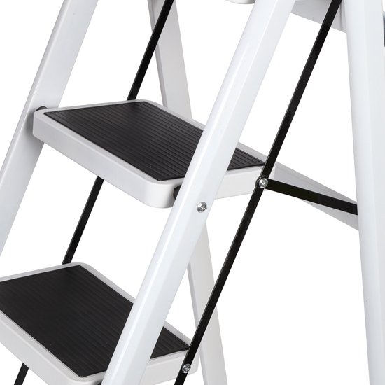Gedetailleerd zicht op de onderste treden van de witte inklapbare trap met zwarte antislip pedalen.