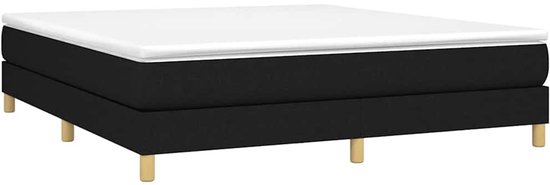 Zwart boxspringbed met een wit matras en houten pootjes.