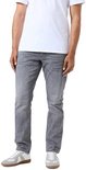 Man met grijze slim fit jeans en witte sneakers.
