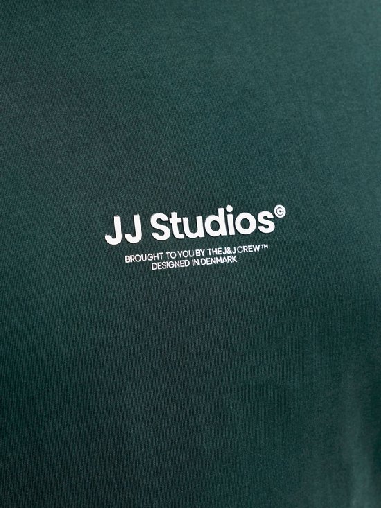 Detail van de witte tekst 'JJ Studios' op een donkergroen T-shirt.