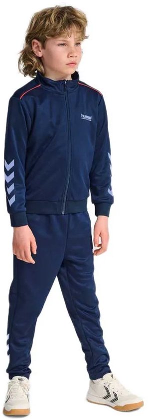 Jongen draagt donkerblauw trainingspak met ritsjack en broek, rode bies en witte chevrons.