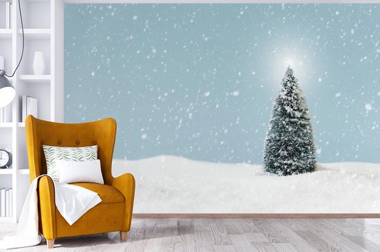 Behang - Fotobehang Een kerstboom in een besneeuwd landschap en een blauwe hemel - Breedte 525 cm x hoogte 350 cm