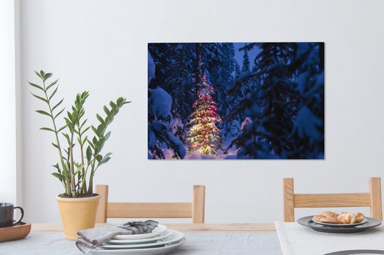 Canvas Schilderij Een kerstboom in het besneeuwde bos - 90x60 cm - Wanddecoratie - OneMillionCanvasses