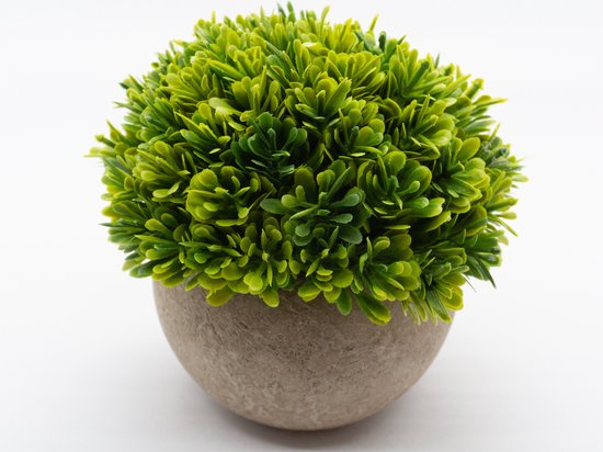 Plante artificielle verte aux petites feuilles torsadées dans un pot rond gris.