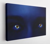 Creatieve foto van het gezicht van een vrouw met neon lichtblauwe kleur en gloeiende veelkleurige ogen met een mysterieuze intense look. Gloeien in de donkere ogen close-up macro.