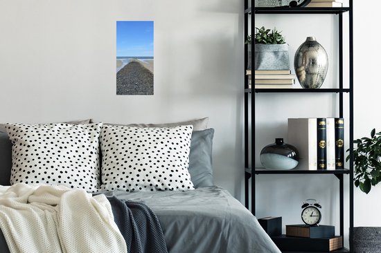 Poster van een stenen dam op weg naar de zee, boven een bed.