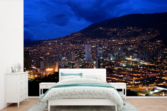 Behang - Fotobehang Stad van Medellín schemer achter de heuvel Nutibara - Breedte 390 cm x hoogte 260 cm