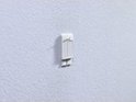 tesa Powerstrip avec deux bandes adhésives sur un papier peint texturé.