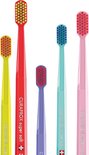 Vijf Curaprox tandenborstels in verschillende kleuren: geel, rood, paars, turkoois en roze.
