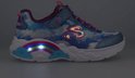 Blauwe en paarse meisjes sneaker van Skechers met regenboogprint, roze veters en glitterdetails. De regenboog aan de zijkant is verlicht.