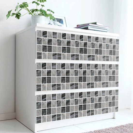 Commode blanche avec façades de tiroirs recouvertes de mosaïques en marbre noir et gris.