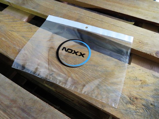Emballage en plastique transparent avec logo "NDXX" bleu et noir, posé sur des palettes en bois.