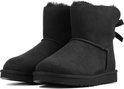 Paar zwarte UGG enkellaarzen met strik op de achterkant en schapenvacht voering.