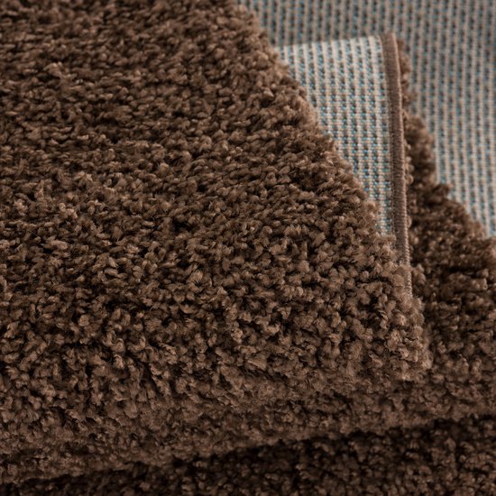 Gedetailleerde close-up van de bruine, pluizige pool van een vloerkleed.