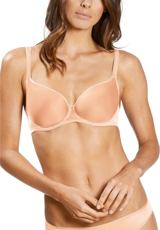 Model in een perzikkleurige beugelbeha met gladde cups en bijpassende slip.