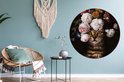 Ronde muurcirkel met kat met bloemenkrans, in een woonkamer met fauteuil.