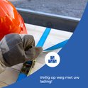 Hand met werkhandschoen die blauwe spanband op houten kist bevestigt, oranje helm.
