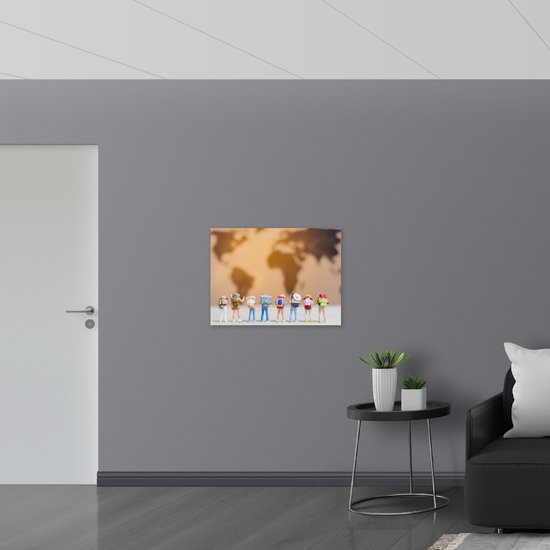 Muursticker - Groepje Miniatuurpoppetjes kijkend naar Wereldkaart - 80x60 cm Foto op Muursticker