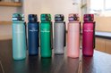 Zes King Mungo drinkflessen in de kleuren lichtblauw, donkerblauw, groen, grijs, roze en paars.