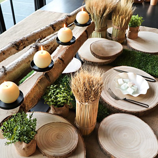 Houten boomschijf decoratie met brandende kaarsen en tarwestengels.