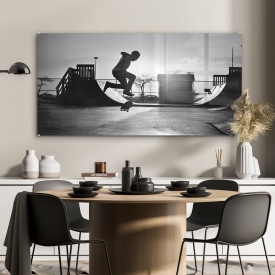 Peinture sur verre MuchoWow® - Un garçon fait une cascade avec son skateboard pendant le coucher du soleil - noir et blanc - 120x60 cm - Peintures sur verre acrylique - Photo sur Glas
