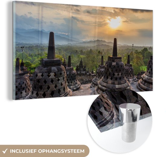 MuchoWow® Glasschilderij 160x80 cm - Schilderij acrylglas - Zonsondergang boven de groene bomen bij de Borobudur - Foto op glas - Schilderijen