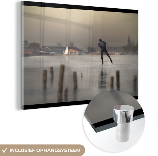 MuchoWow® Glasschilderij 90x60 cm - Schilderij acrylglas - Een schaatser gaat over de binnenmeren van Volendam - Foto op glas - Schilderijen