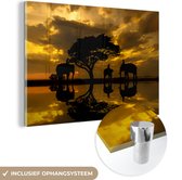 MuchoWow® Glasschilderij 150x100 cm - Schilderij acrylglas - Silhouet van Thaise olifanten tijdens zonsopgang - Foto op glas - Schilderijen