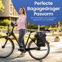 Vrouw met zwarte NAYD fietstas op de bagagedrager van haar fiets. De tas is 25L en ontworpen voor stabiliteit.